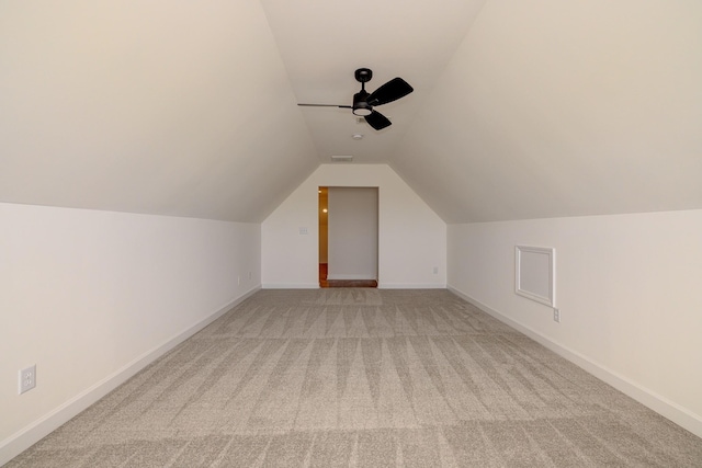 additional living space featuring lofted ceiling, light carpet, visible vents, a ceiling fan, and baseboards