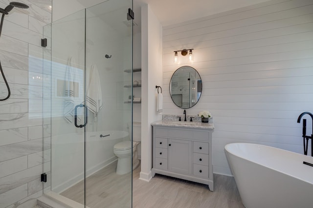 bathroom with a stall shower, a freestanding tub, and vanity