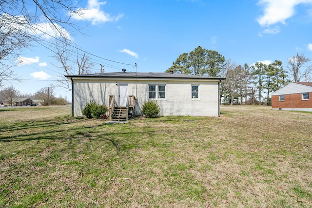 rear view of property with a lawn and brick siding