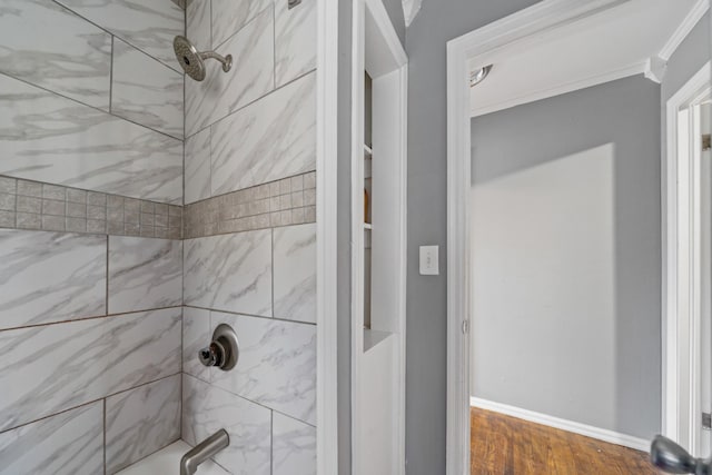 bathroom with crown molding, baseboards, and wood finished floors