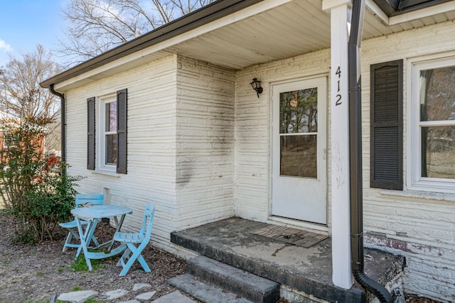 doorway to property with brick siding