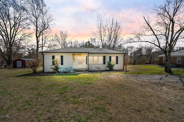 view of front of house with entry steps, a front lawn, and an outdoor structure