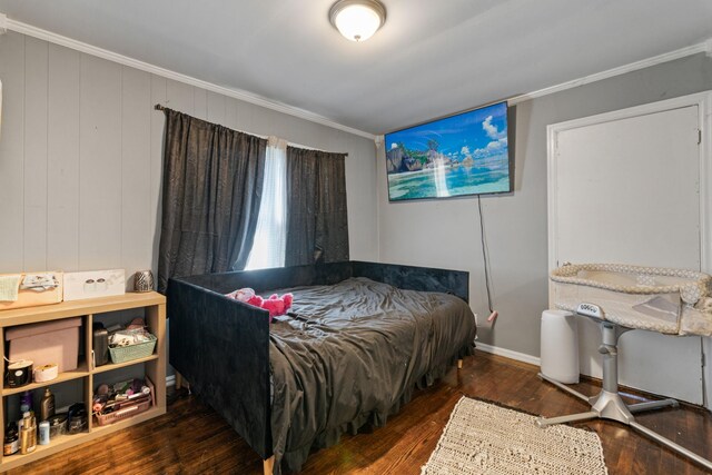 bedroom with baseboards, hardwood / wood-style flooring, and crown molding