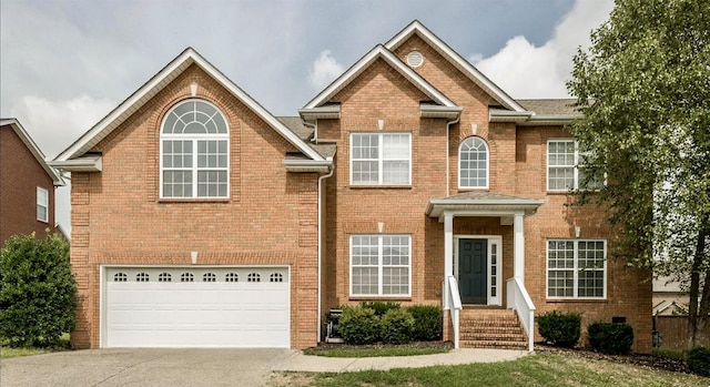 view of front facade with brick siding, an attached garage, and driveway