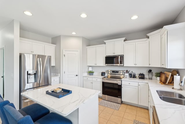 806 Warrington Ct, Gallatin, TN 37066 - kitchen with a kitchen island, a breakfast bar, white cabinets, stainless steel appliances, and a sink