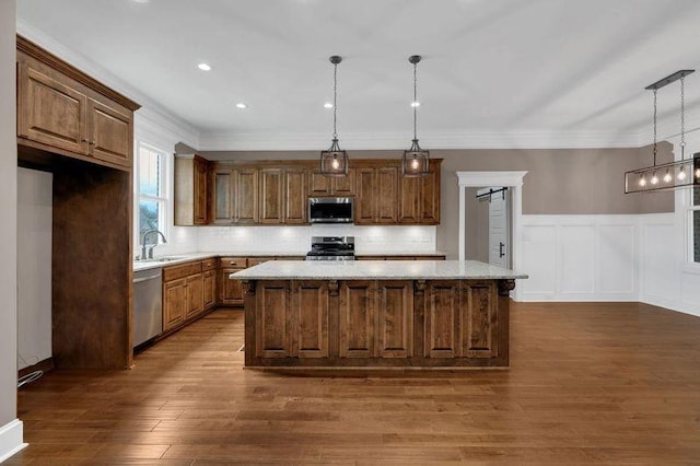 kitchen with stainless steel appliances, a center island, dark wood-style flooring, and crown molding