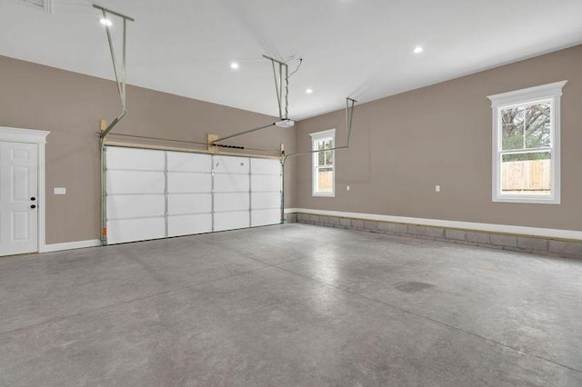 garage with a garage door opener and recessed lighting