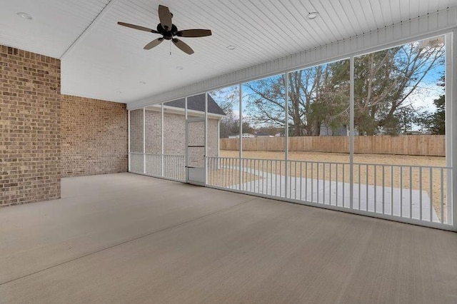 unfurnished sunroom featuring ceiling fan