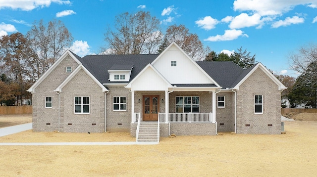 view of front of home with a porch, crawl space, and brick siding