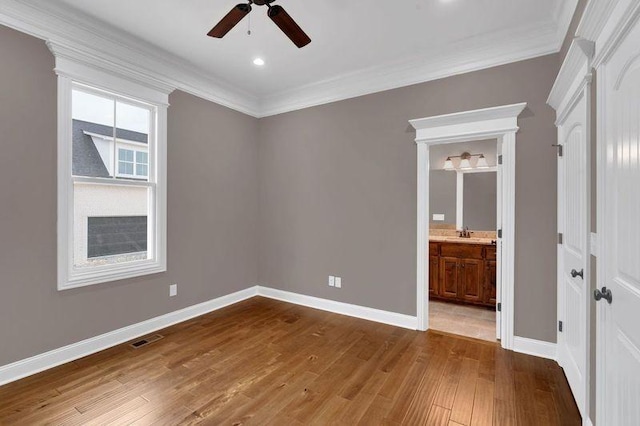 unfurnished bedroom with dark wood-style floors, visible vents, ornamental molding, and baseboards