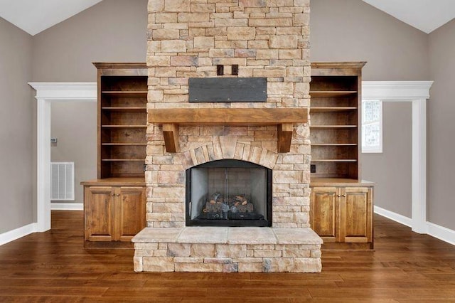 room details with a fireplace, wood finished floors, visible vents, and baseboards