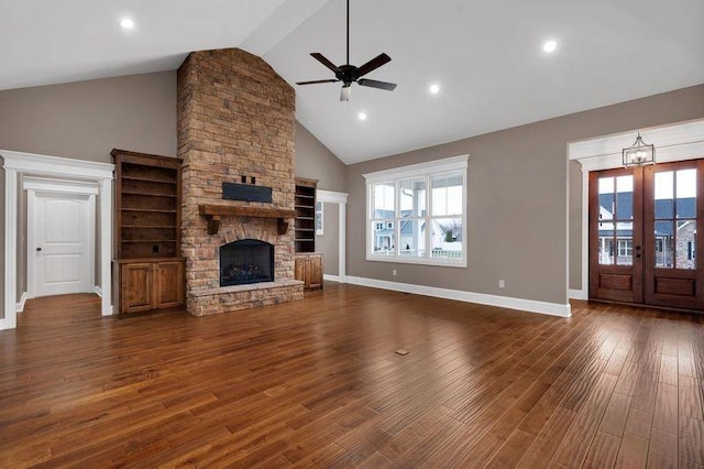 unfurnished living room featuring a healthy amount of sunlight, a fireplace, dark wood-style flooring, and french doors