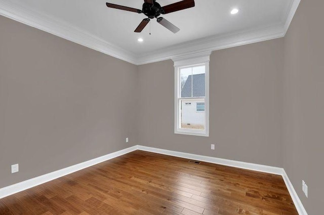 unfurnished room featuring visible vents, baseboards, crown molding, and wood finished floors