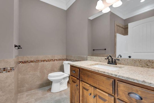 bathroom with crown molding, tile walls, toilet, vanity, and tile patterned floors