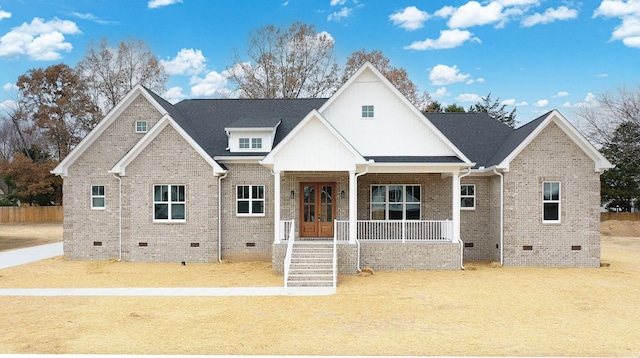 view of front of house featuring crawl space, roof with shingles, a porch, and brick siding