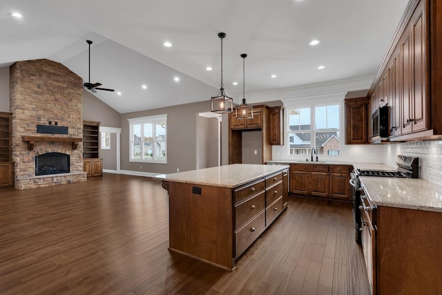 kitchen featuring a fireplace, dark wood finished floors, tasteful backsplash, appliances with stainless steel finishes, and open floor plan