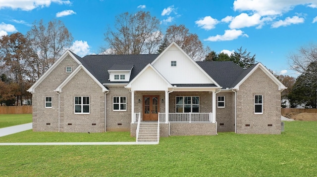 view of front of house featuring crawl space, brick siding, a porch, and a front yard