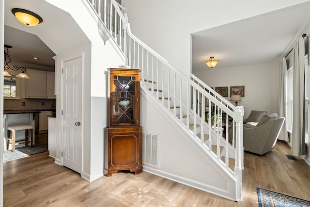 stairway featuring visible vents and wood finished floors