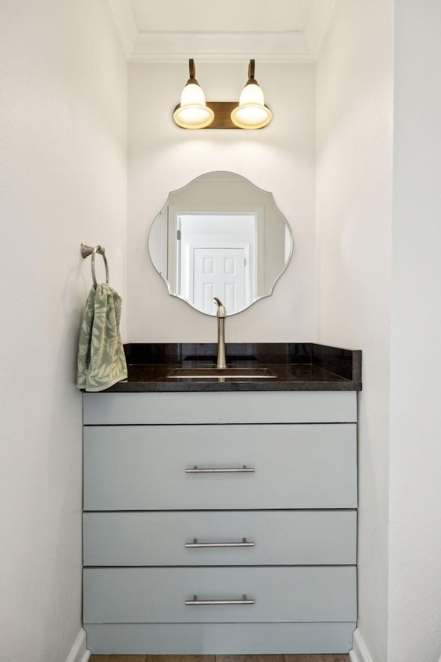 bathroom with baseboards, ornamental molding, and vanity