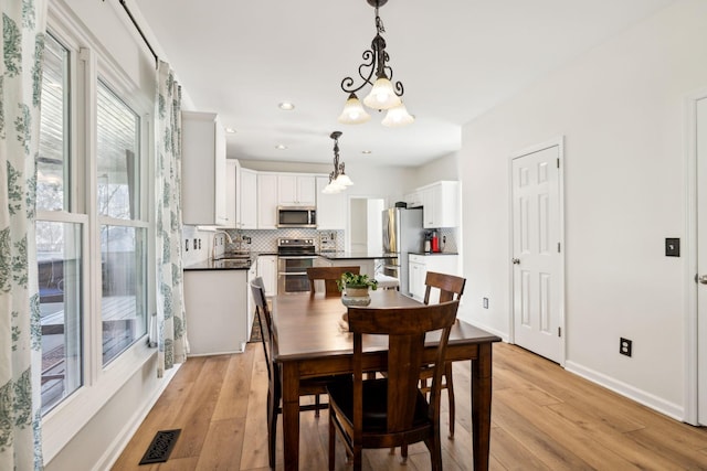 dining room featuring light wood-style floors, recessed lighting, visible vents, and baseboards