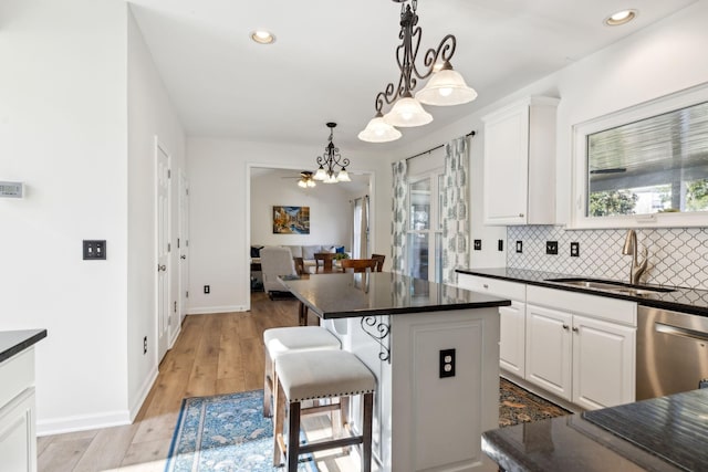 kitchen with dishwasher, dark countertops, and a sink