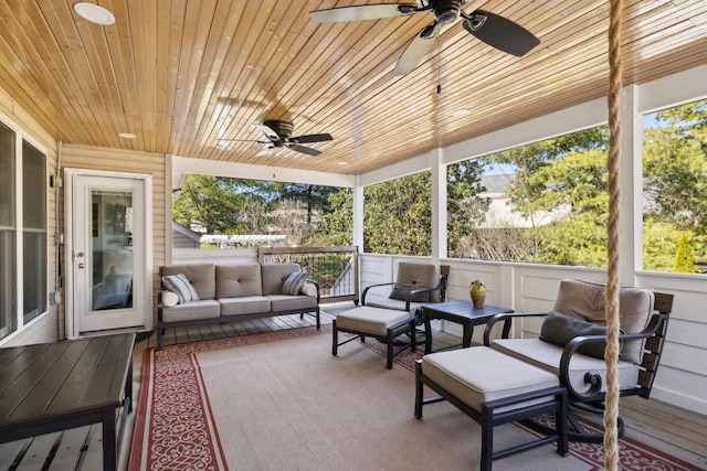 sunroom with ceiling fan, wooden ceiling, and a wealth of natural light