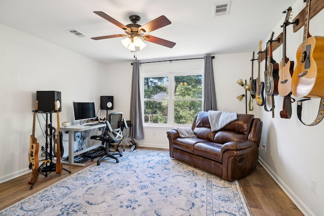 office featuring a ceiling fan, visible vents, baseboards, and wood finished floors