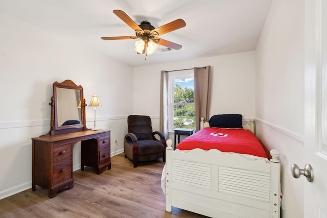 bedroom with a ceiling fan, visible vents, light wood-style flooring, and baseboards