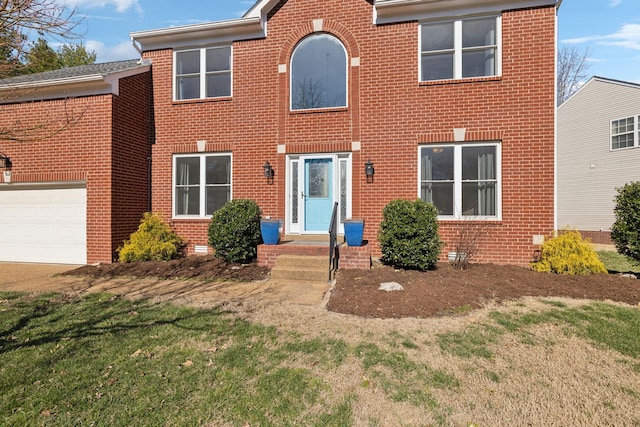 colonial home featuring a garage and brick siding