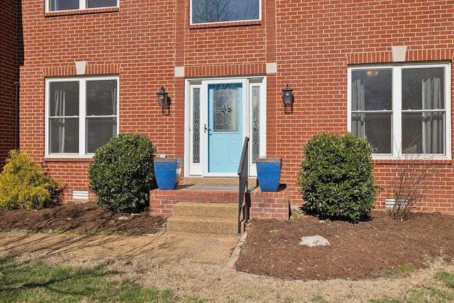 property entrance with crawl space and brick siding