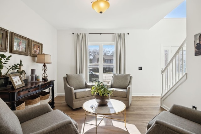 living area featuring stairs, baseboards, and wood finished floors