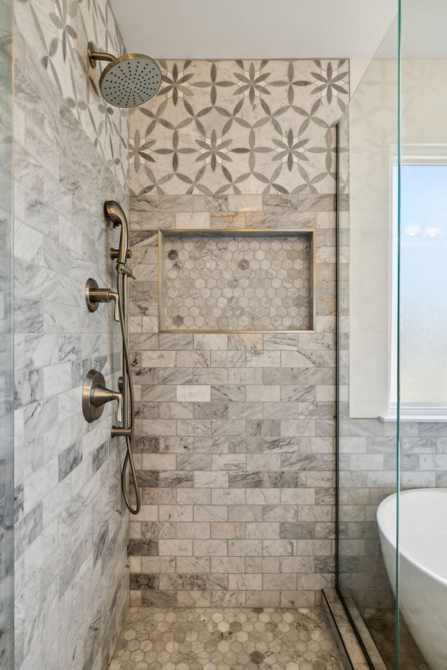 bathroom with a soaking tub and tiled shower