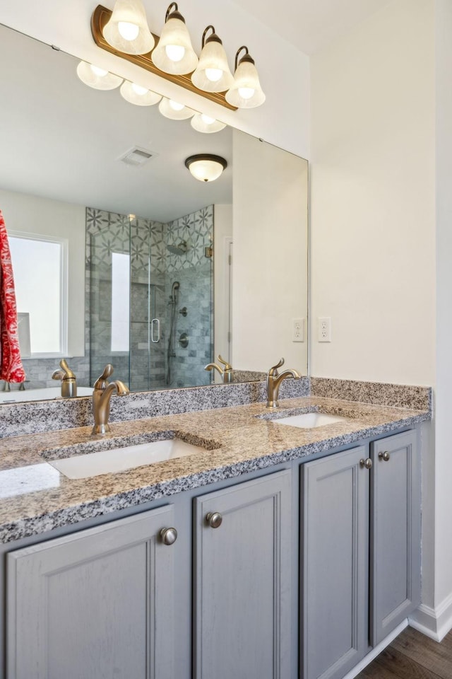 full bathroom featuring double vanity, a sink, visible vents, and a shower stall