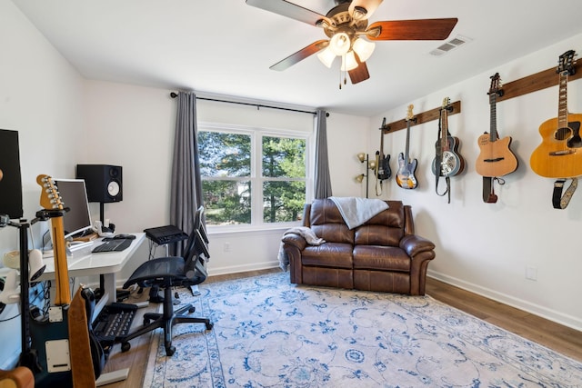 office area featuring a ceiling fan, baseboards, visible vents, and wood finished floors