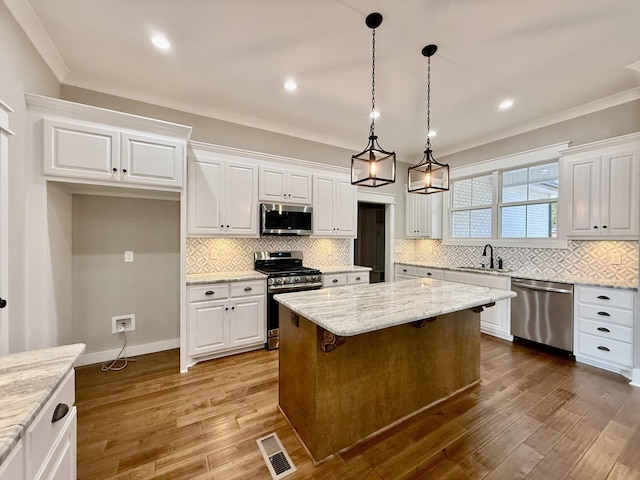 kitchen with stainless steel appliances, dark wood-type flooring, a sink, visible vents, and white cabinetry