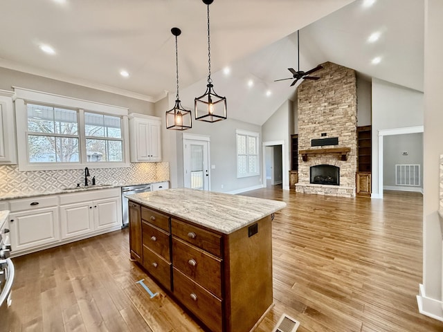 kitchen with a sink, visible vents, light wood-style floors, white cabinetry, and dishwasher