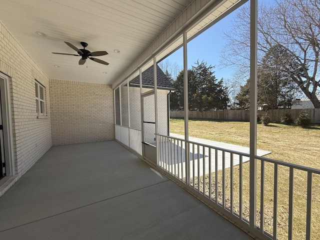 unfurnished sunroom featuring ceiling fan