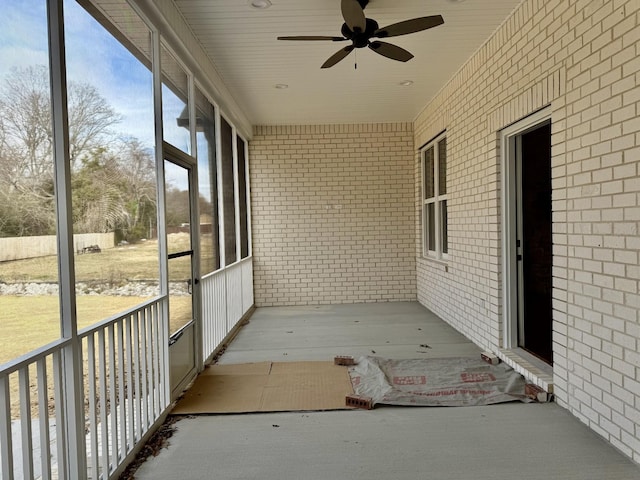 unfurnished sunroom featuring a ceiling fan