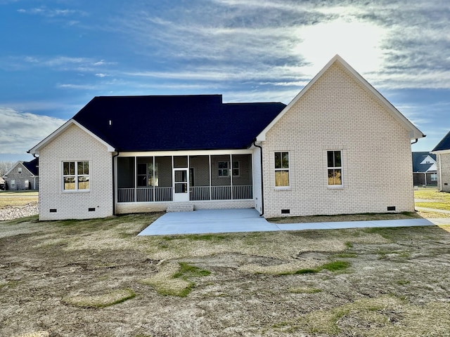 rear view of house with brick siding, crawl space, and a sunroom