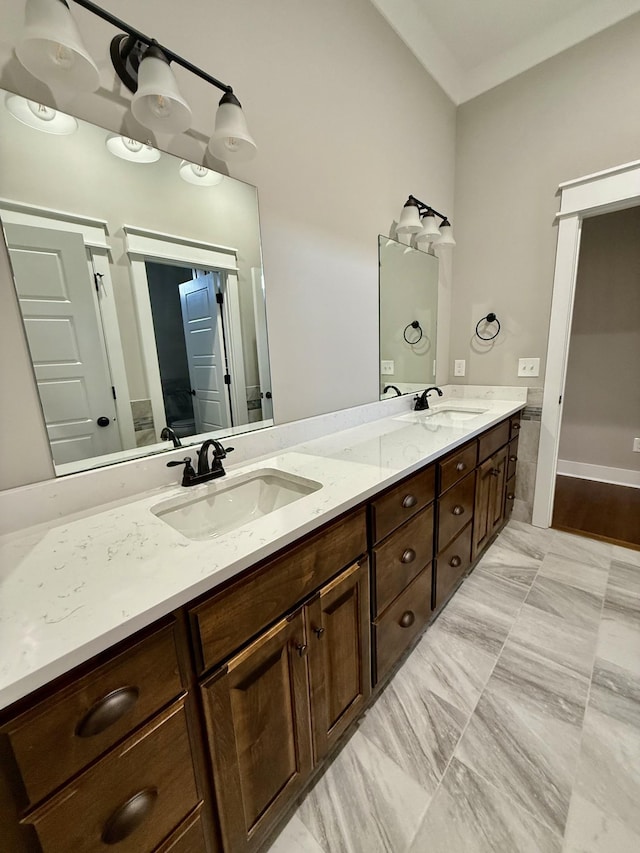 bathroom featuring crown molding, a sink, and double vanity