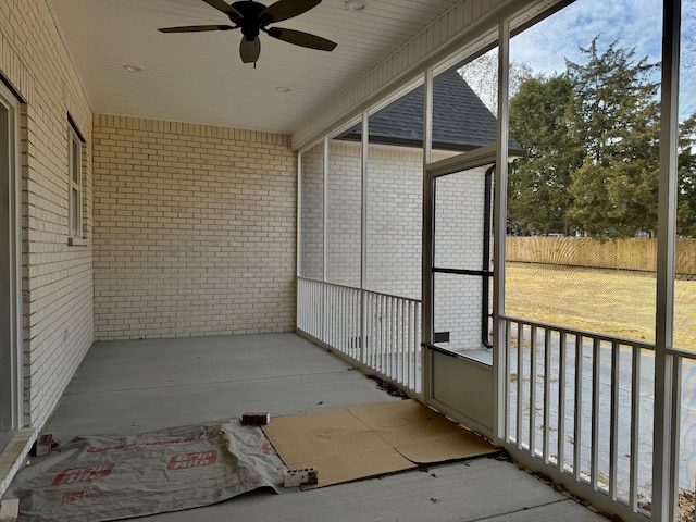 unfurnished sunroom with ceiling fan