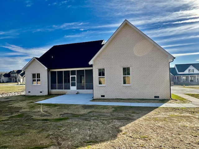 rear view of property featuring brick siding, crawl space, and a sunroom