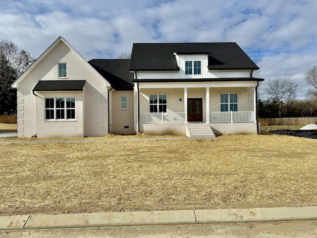 view of front of house featuring a porch, french doors, and brick siding