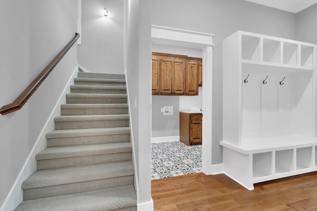 stairway with baseboards and wood finished floors