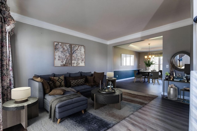 living area featuring baseboards, crown molding, an inviting chandelier, and wood finished floors