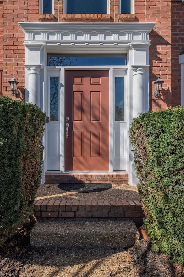 entrance to property featuring brick siding