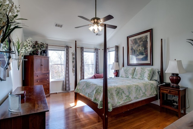 bedroom featuring vaulted ceiling, wood finished floors, visible vents, and a ceiling fan