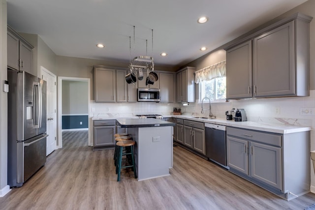 kitchen with gray cabinets, stainless steel appliances, and a sink