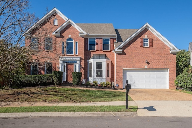 view of front facade with a garage, a front yard, concrete driveway, and brick siding