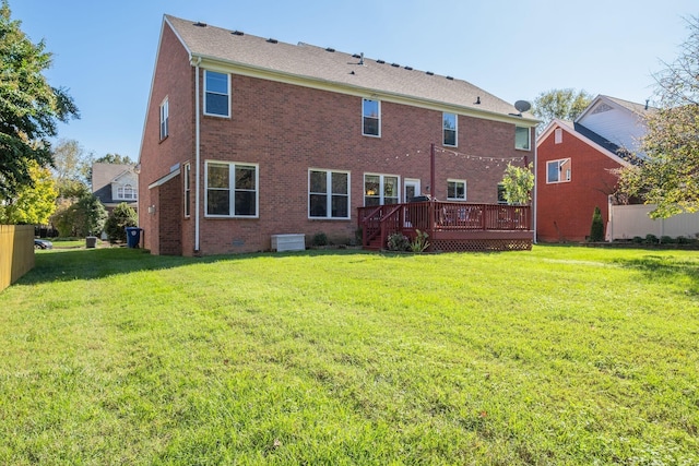 back of property with a deck, brick siding, fence, a yard, and crawl space